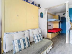 a room with a couch and a bunk bed at Vacances au port in Saint Cyprien Plage