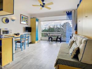 a living room with a couch and a kitchen with a table at Vacances au port in Saint Cyprien Plage