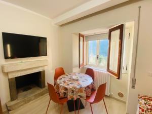 a dining room with a table and chairs and a television at la cASa in Acquaviva dʼIsernia