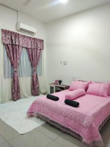 a pink bed in a white room with curtains at Homestay Alor Setar - VILLA FARAH in Alor Setar