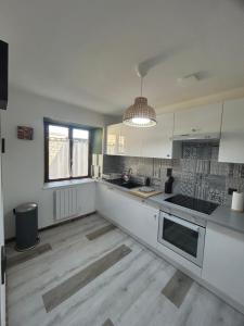 a large kitchen with white cabinets and a window at Maison 4 personnes, TV connectée in Joinville