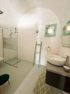 Un baño con lavabo y ducha de cristal. en Casa Trullo Bianco-Casa Olive, en Ceglie Messapica 16 fotos más