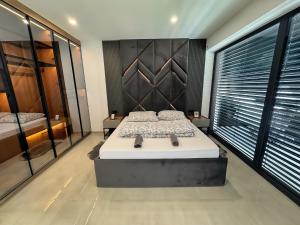 a bedroom with a large bed and a large window at Design-Villa mit privatem Pool, Whirlpool & stimmungsvoller Beleuchtung in Linz +24 photos