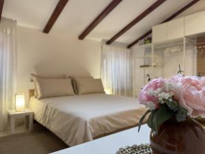 a bedroom with a bed and a vase of flowers on a table at Locandina Jure in Rovinj