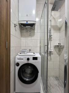 a washing machine in a bathroom with a shower at DIS LUX Apartments in Radanovići