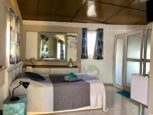 a bedroom with a bed with a mirror and a lamp at Sabina villa in Pereybere