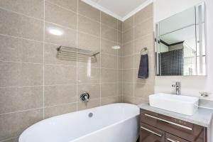 Un baño con bañera blanca y lavabo. en AlimamaSpaces The Manson's Walford, en Midrand 13 fotos más
