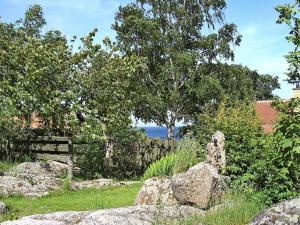 a garden with rocks and a fence and a tree at 4 person holiday home in Allinge-By Traum in Allinge