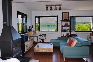 La Puebla de CastroにあるLa Casa del Lago con vistas a las Montañasの青いソファと暖炉のあるリビングルーム