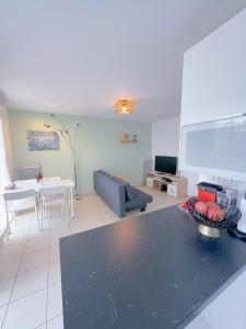 a living room with a couch and a table at Proche Disney Paris Appartement cosy et familial pour 4 Pers-Wifi-Parking Privé in Bussy-Saint-Georges