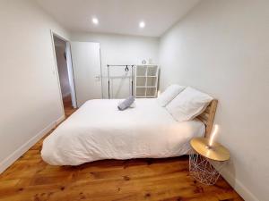 a bedroom with a large white bed and a lamp at Les Arcades - Mirande Centre in Mirande