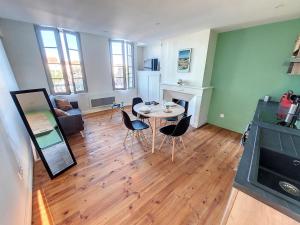 a living room with a table and chairs at Les Arcades - Mirande Centre in Mirande