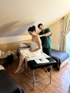 a man and a woman sitting on a bed at Penzión Liezky in Mýto pod Ďumbierom