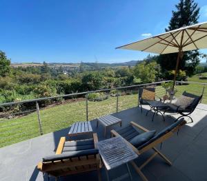 a patio with a table and chairs and an umbrella at Paradies in der Vulkaneifel - Panorama-Blick und Wintergarten für jedes Wetter in Burgbrohl