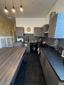 シェフィールドにあるCentral Sheffield 3-Bed Apt Sleeps 7 with Parkingの部屋にある木製のカウンタートップを備えたキッチン