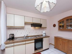 a kitchen with white cabinets and a sink at Müllenborn Mountain Nest in Gerolstein