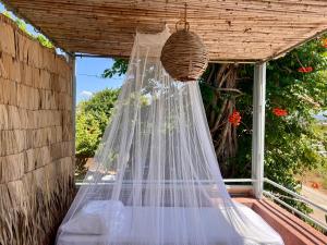 a net hanging on a porch with a window at Garden Studio -Designed for rest, built for two in Kourouta