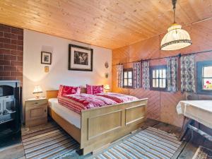 ein Schlafzimmer mit einem Bett mit roten Kissen in der Unterkunft Chalet in Arriach near Gerlitzen Ski Area in Arriach