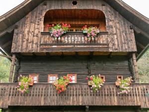 ein Holzhaus mit Blumen in den Fenstern in der Unterkunft Chalet in Arriach near Gerlitzen Ski Area in Arriach + 27 Fotos