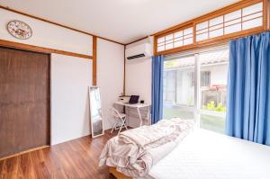 a bedroom with a bed and a window at サフラン in Kumejima