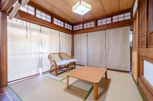 a room with a chair and a table and windows at サフラン in Kumejima +18 photos