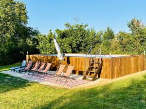 a group of chairs sitting in front of a pool at Le Pavillon, Grand Manoir du XVIIe avec Piscine, Bain Nordique et accès privé à la Charente in Alloué