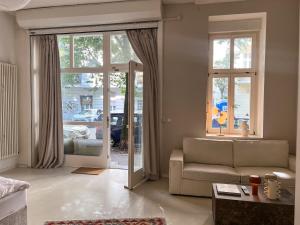 un salon avec un canapé et une grande fenêtre dans l'établissement Loft-style design apartment in the heart of Berlin, à Berlin