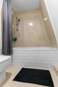 a bathroom with a tub with a shower and a black rug at Large Delux Studio - 26 in Leicester