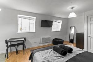 a bedroom with a bed and a table and a desk at Large Delux Studio - 26 in Leicester +4 photos