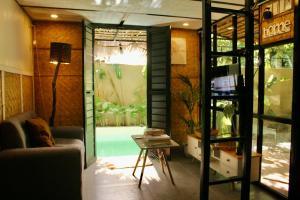 a living room with a couch and a glass door at Kamia Tiny Rest House in Sampong