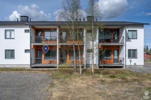 アカスロンポロにあるHoliday in Lapland - Ylläs Sivulantie 107の前に木がある白い建物
