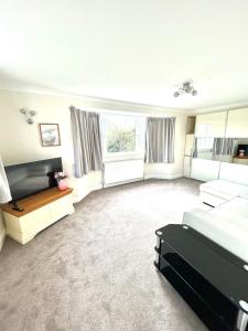 Una gran sala de estar con una cama y un sofá. en Wonderful two bedroom bungalow in Oxford, en Kidlington