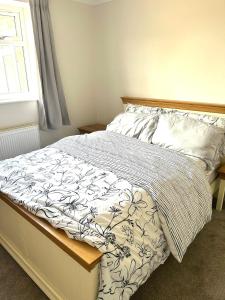 Un dormitorio con una cama con una manta y una ventana. en Wonderful two bedroom bungalow in Oxford, en Kidlington 30 fotos más