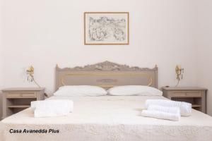 a bedroom with a white bed with two night stands at A Vanedda in Noto