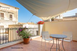 a patio with a table and chairs on a balcony at A Vanedda in Noto