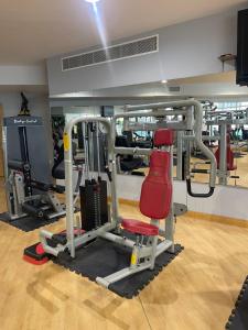a gym with several tread machines and a red chair at Bahrain Amwaj in Amwaj Island
