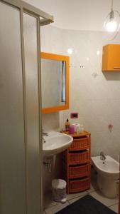 een badkamer met een wastafel, een toilet en een spiegel bij Noemi House & Rooms in Novara