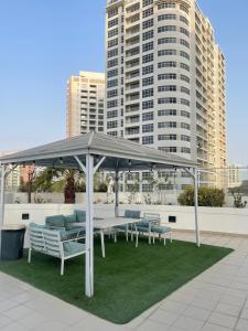 a gazebo with chairs and tables on a lawn at Bahrain Amwaj in Amwaj Island