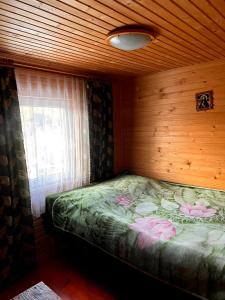 a small bedroom with a bed with a window at Магурчик in Vorokhta