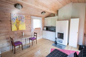 a kitchen with a table and chairs and a refrigerator at Poromoision pirtti in Peurasuvanto +10 photos