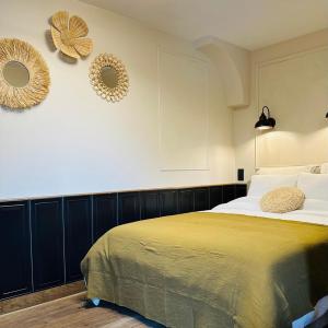 a bedroom with a bed and two mirrors on the wall at OrigiNell - EmotioNell in Ouffet