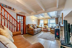 Una sala de estar con sofás y chimenea. en Victoria House - St Issey, en Saint Issey