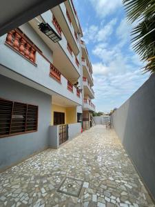 a building with a stone walkway in front of it at Les Résidences Perpetue in Abomey-Calavi