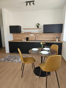 a kitchen with a table and chairs and a counter at Úplne nový Apartmán Kvetinka v centre Žiliny in Žilina