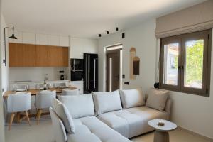 a living room with a white couch and a kitchen at Bona Eterna Timeless Suites in Spílion