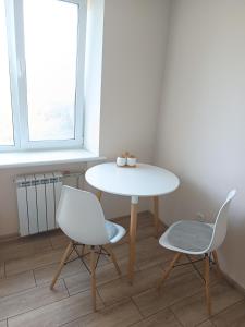 a white table and two chairs in a room at Soft House in Mykolaiv