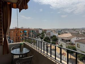 ein Balkon mit Tisch und Blick auf eine Stadt in der Unterkunft Campo de la Verdad Home Luxury in Córdoba