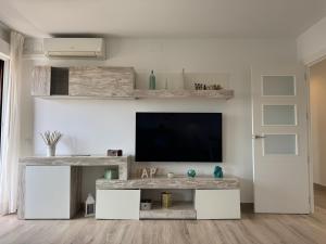 ein Wohnzimmer mit einem Fernseher an einer weißen Wand in der Unterkunft Campo de la Verdad Home Luxury in Córdoba