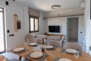 a dining room with a table and chairs and a television at Bona Eterna Timeless Suites in Spílion