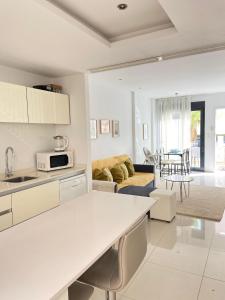 a kitchen and living room with white cabinets at Duplex Zenia beach, La zenia in Playa Flamenca